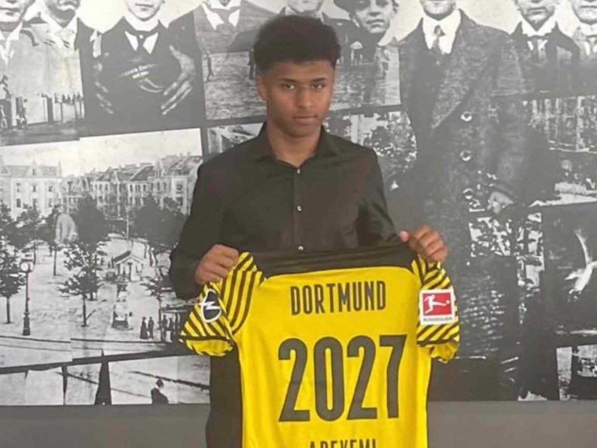 In this image - Karim Adeyemi holding a Borussia Dortmund kit during his unveil.