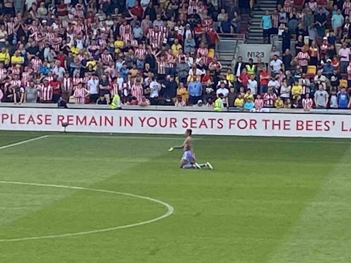 The photo shows Raphinha Raphinha walking the length of the pitch on his knees after Leeds United secured survival